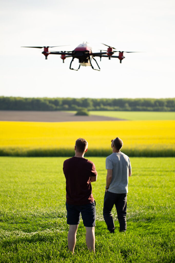 Technician farmer use wifi computer control agriculture drone on sugarcane field.